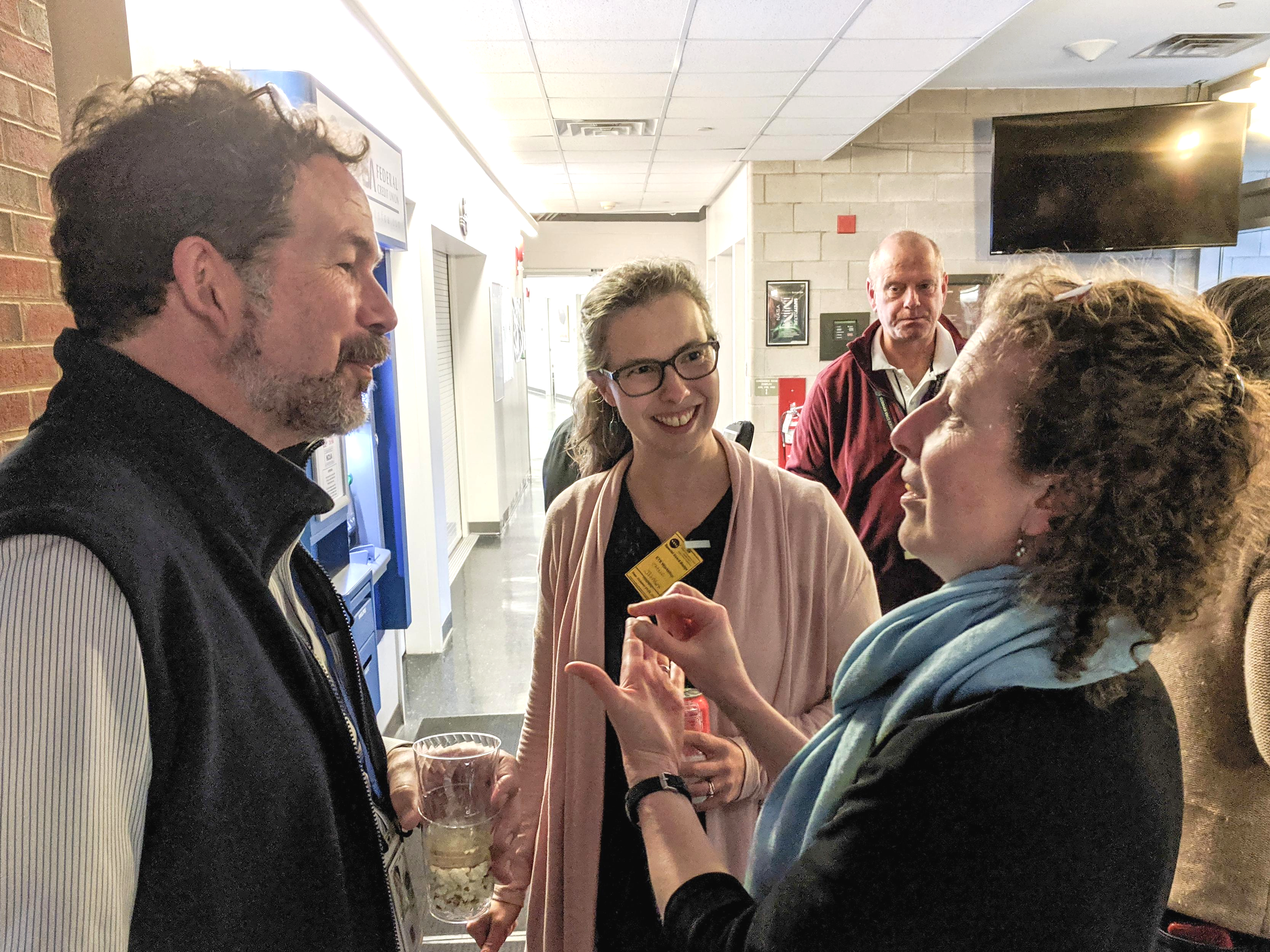 A group of three people speak together